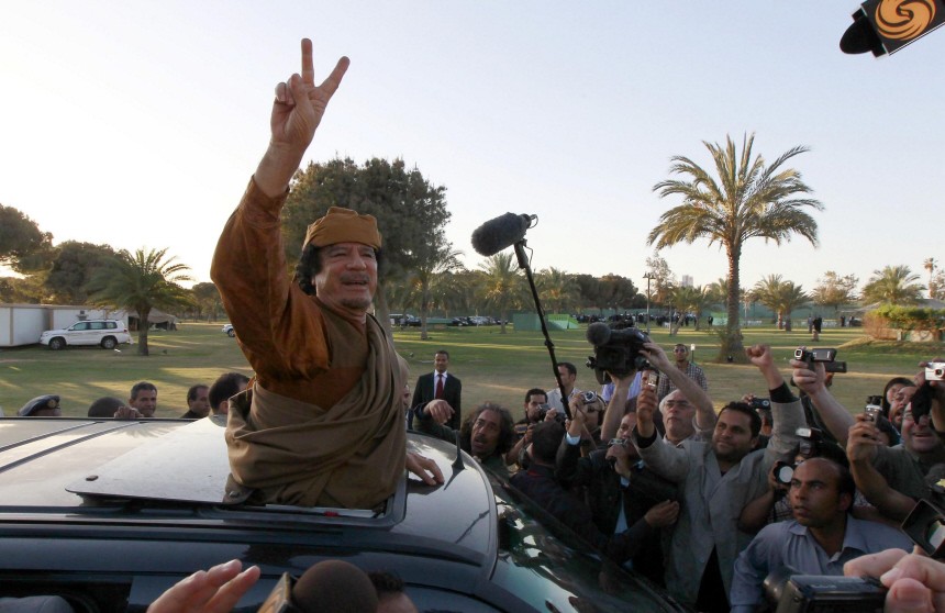 Libyan leader Muammar Gaddafi gestures from a car in the compound of Bab Al Azizia in Tripoli
