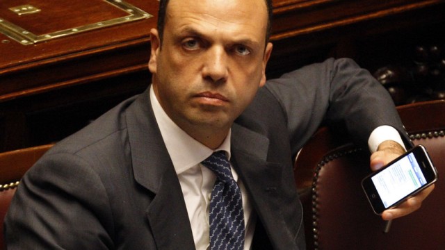 Italy's Justice Minister Angelino Alfano sits as he holds his iPhone at the lower house of parliament in Rome