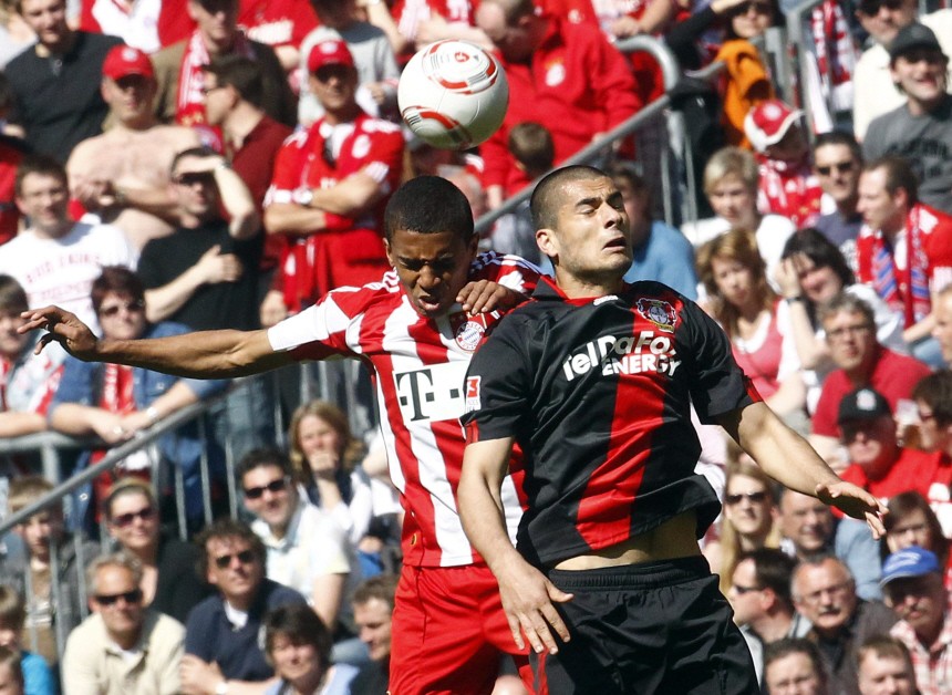Gustavo of FC Bayern Munich challenges Derdiyok of Bayer 04 Leverkusen during their German first division Bundesliga soccer match in Munich
