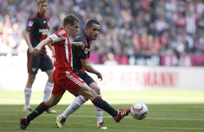 Bayern Munich's Lahm is tackled by Bayer Leverkusen's Augusto during German Bundesliga soccer match in Munich