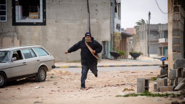 Krieg in Libyen: Ein Mann versucht sich in Misrata in Sicherheit zu bringen: Die Stadt wurde offenbar von den Truppen Gaddafis zurückerobert.
