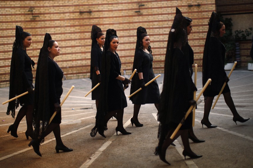 Women wearing traditional mantilla dresses take part in the procession of the 'Estrella' brotherhood during Holy Week in Malaga