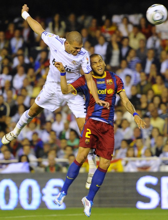 Real Madrid's Pepe and Barcelona's Alves jump for the ball during their King's Cup final soccer match at Mestalla stadium in Valencia