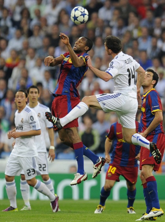 Real Madrid's Xabi Alonso jumps for the ball against Barcelona's Seydou Keita during their Champions League semi-final first leg soccer match at Santiago Bernabeu stadium
