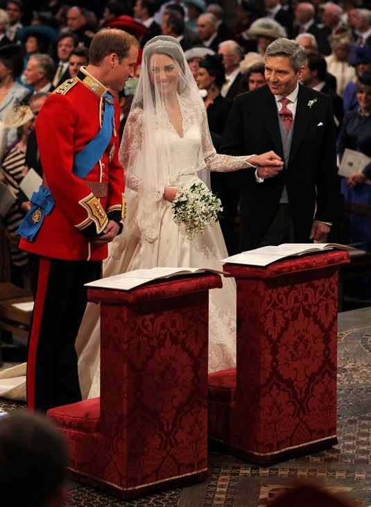 Britain's Prince William stands at the altar with his bride, Kate Middleton, and her father Michael, during their wedding at Westminster Abbey in central London