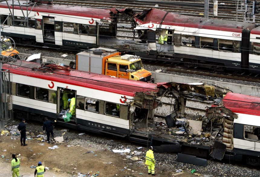 File photo of railway workers removing debris from the wreckage of a bombed public train in Madrid