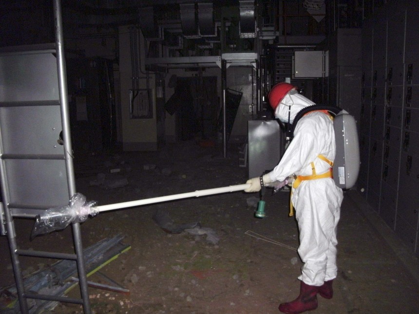 Handout photo of a worker wearing protective suit while measuring radiation levels inside of the Tokyo Electric Power Co.'s crippled Fukushima Daiichi Nuclear Power Plant No.1 reactor building in Fukushima