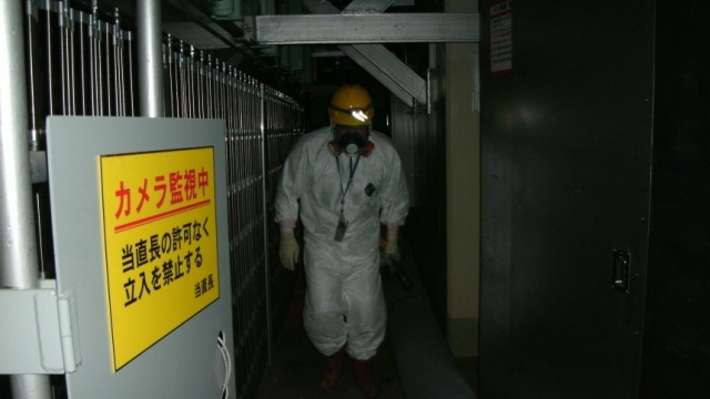 A worker walks through Tokyo Electric Power's Fukushima Daiichi Nuclear Power Plant's Unit 1 reactor in Fukushima prefecture in this handout photo released by TEPCO