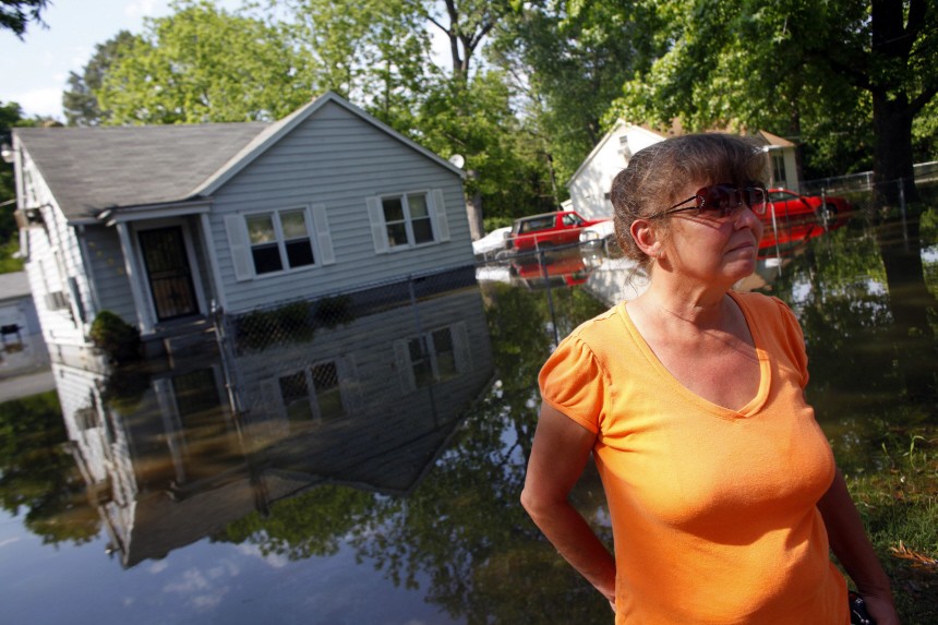 Penny Burton stands in front of her home as floodwaters slowly rise in Memphis, Tennessee