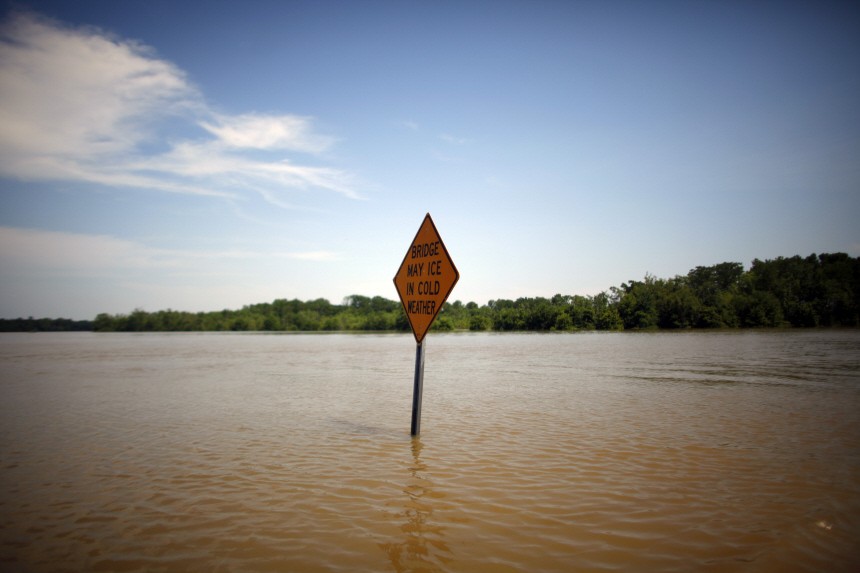 A sign is seen on a road as floodwaters slowly rise in Holly Grove, Arkansas