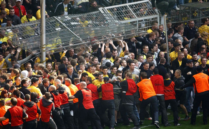 Security staff try to push back Borussia Dortmund supporters after their German first division Bundesliga soccer match against Eintracht Frankfurt in Dortmund