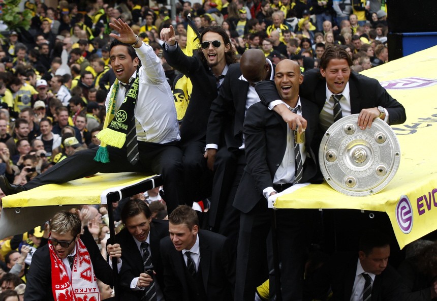 Borussia Dortmund's players celebrate with the German soccer championship trophy on their way to a reception in Dortmund