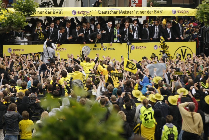 Borussia Dortmund supporters celebrate their team with the German soccer championship trophy on their way to a reception in Dortmund