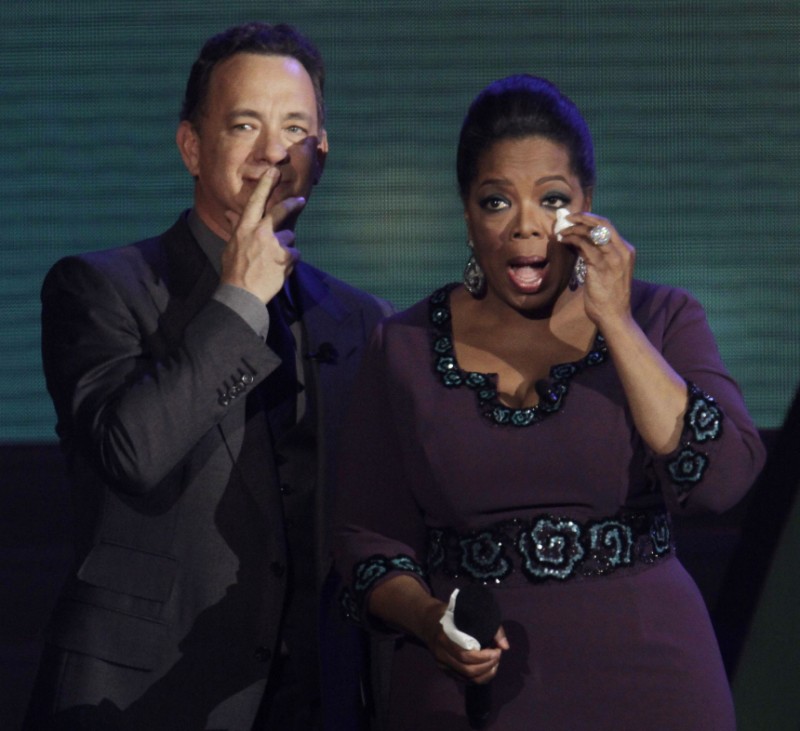 Oprah Winfrey wipes a tear from her eye as she stands with actor Tom Hanks during the taping of 'Oprah's Surprise Spectacular' in Chicago