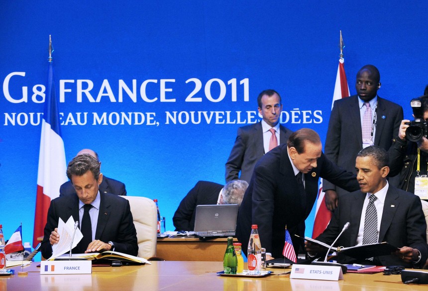 US President Obama listens to Italian Prime Minister Berlusconi before a working session at the G8 summit in Deauville