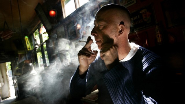 Unidentified man smokes marijuana joint in a coffeeshop in Rotterdam