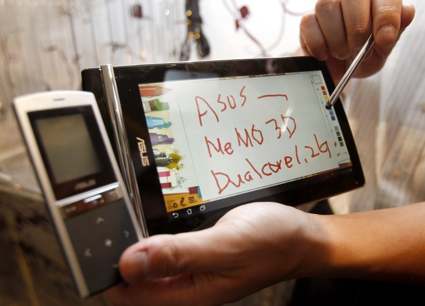 Employee displays Eee Pad MeMO 3D during a news conference at a media preview of the 2011 Computex exhibition in Taipei