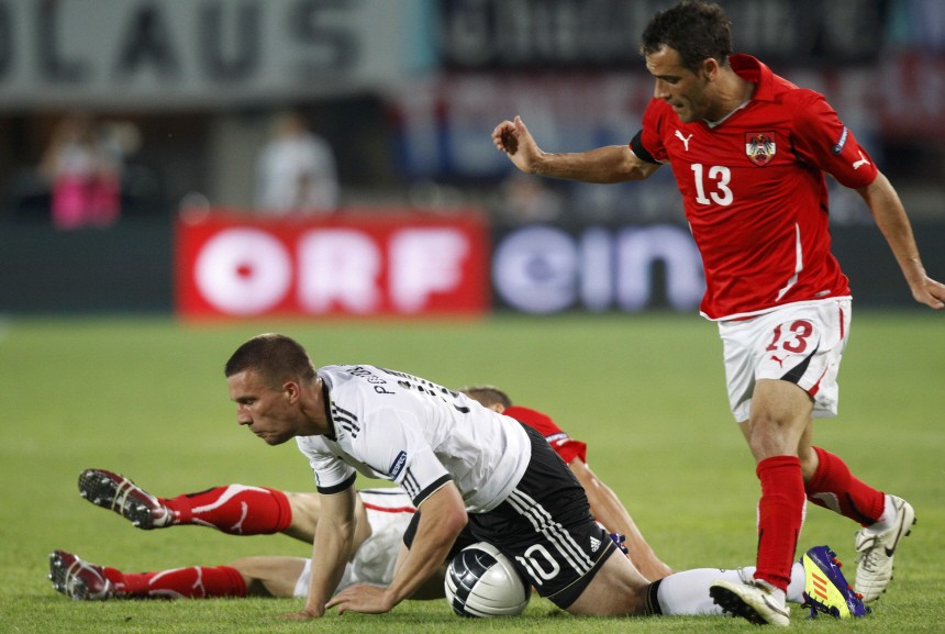 Germany's Podolski falls in front of Austria's Dag during their Euro 2012 Group A qualifying soccer match at the Ernst Happel stadium in Vienna