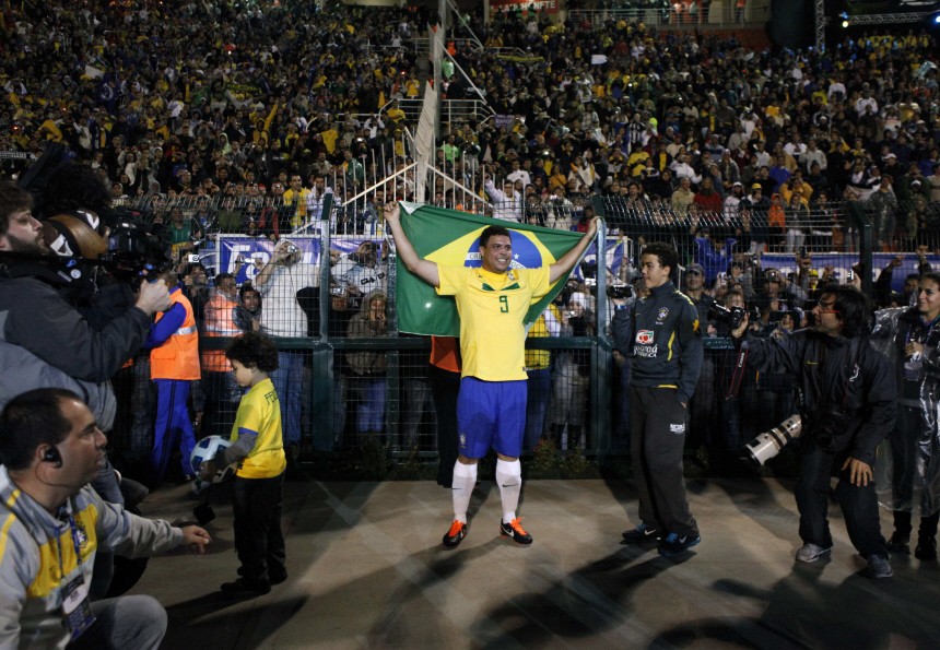 Brazil's Ronaldo holds up a Brazilian flag during his last soccer match with the national squad against Romania in Pacaembu Stadium in Sao Paulo