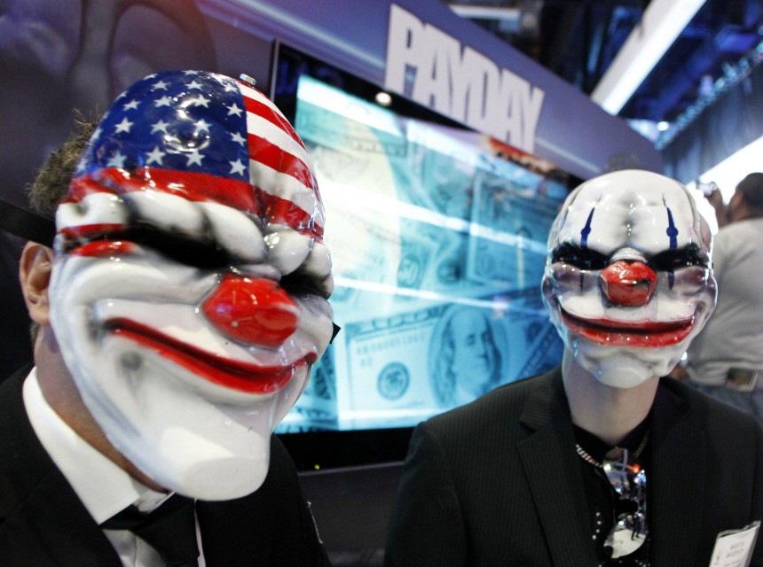 Men wearing masks of characters from 'Payday: The Heist' pose for a photo during E3 in Los Angeles