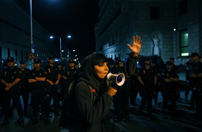 A demonstrator speaks in front of Spain's parliament