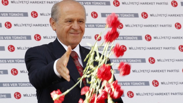 MHP leader Devlet Bahceli hands out carnations during an election rally in Ankara