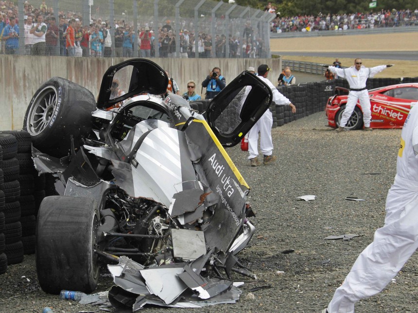 Safety crew members help Britain's Allan Mcnish after he crashed with his Audi R18 TDI during the Le Mans 24-hour sportscar race in Le Mans