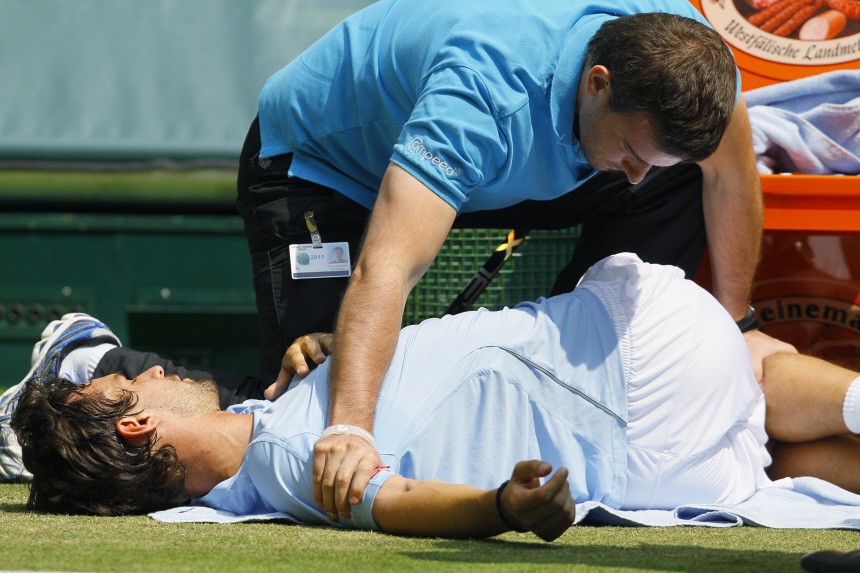 Petzschner of Germany receives medical treatment during his final match against compatriot Kohlschreiber in the Halle Open ATP tennis tournament in Halle