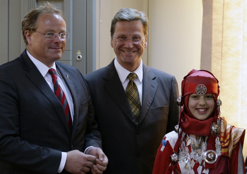 Germany's Foreign Minister Westerwelle and Economic Cooperation and Development Minister Niebel  take a photo with Libyan girl after a news conference in Benghazi