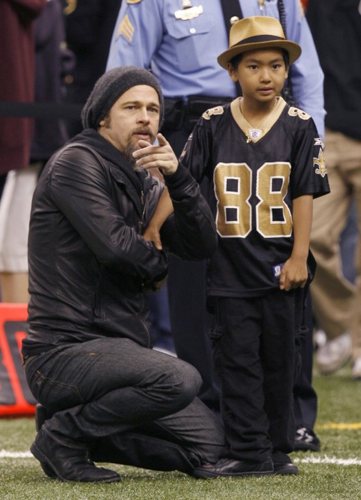 Actor Brad Pitt and son Maddox stand on the field before play between the New Orleans Saints and the Arizona Cardinals in the NFL's NFC Divisional playoff football game in New Orleans