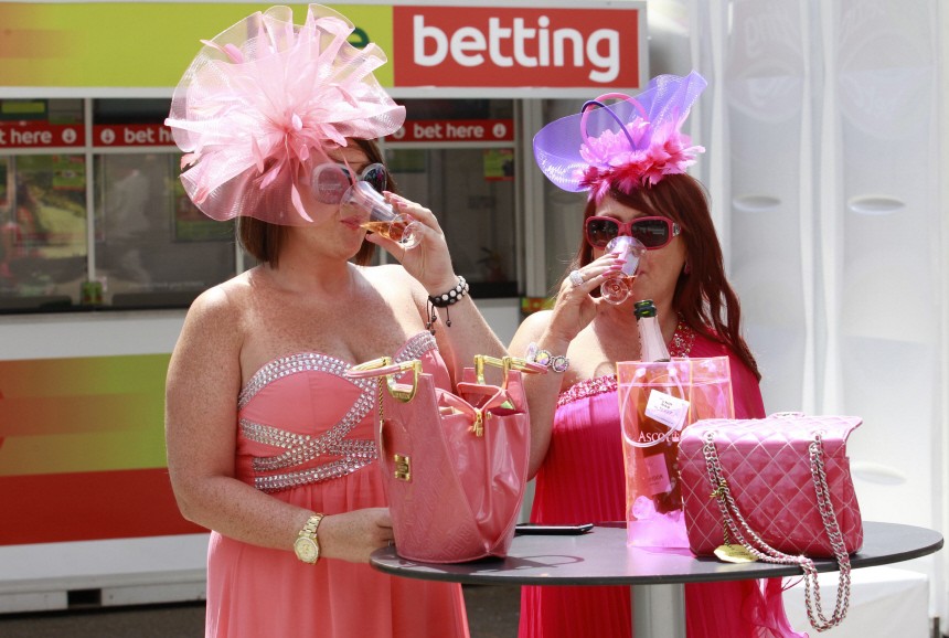 Two women drink champagne outside a betting kiosk on the first day of racing at Royal Ascot in southern England