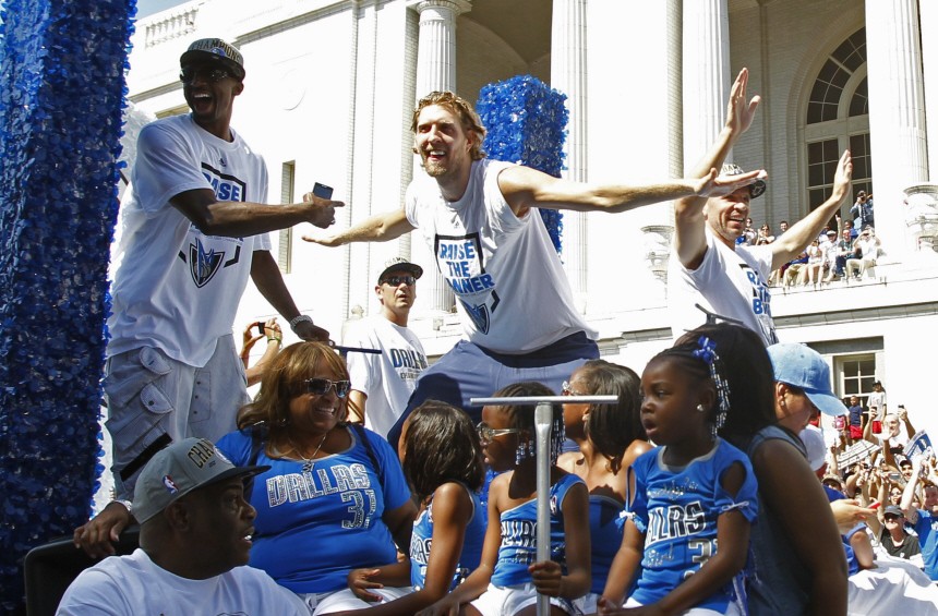 Dallas Mavericks Dirk Nowitzki mimics teammate shooting guard Jason Terry as they ride on a float during a parade to celebrate their NBA championship in Dallas
