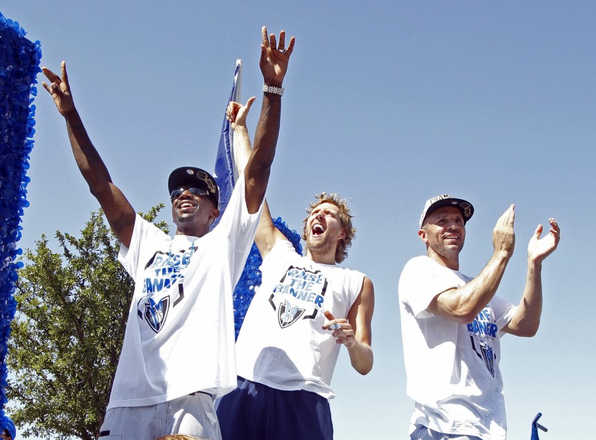 Dallas Mavericks Jason Terry, Dirk Nowitzki and Jason Kidd wave to fans as they ride on a float during a parade to celebrate their NBA championship in Dallas