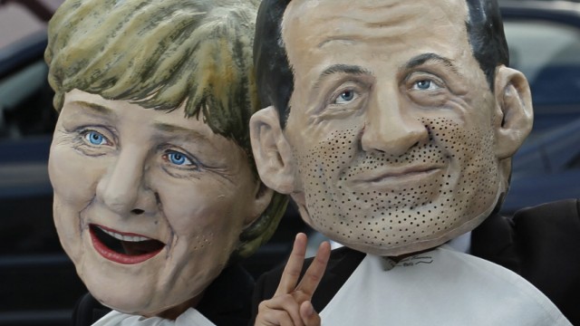 Oxfam's activists wear masks depicting EU leaders during a protest called ' A working lunch for nine billion'  outside the European Parliament in Brussels