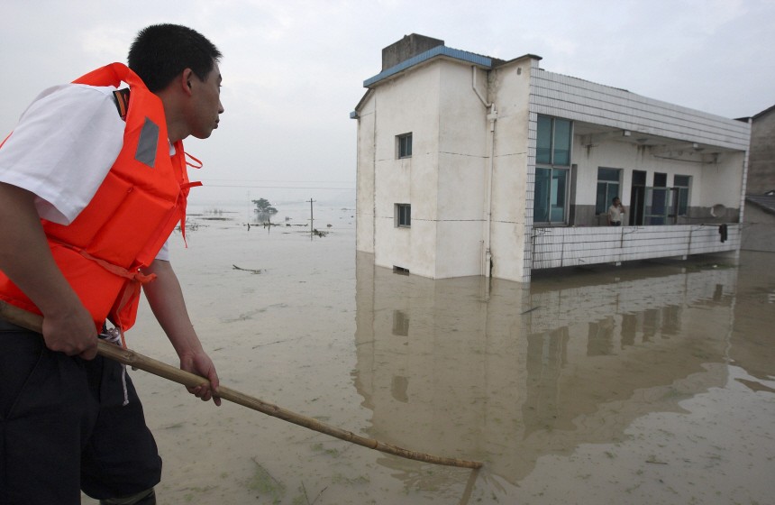 A rescuer evacuates a stranded resident at a flooded village in Zhuji city