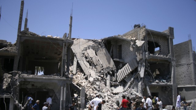 People inspect the rubble of a residential building, which Libyan officials say was hit by a NATO air strike, in Tripoli