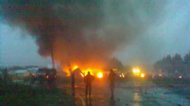 People walk at the site of a plane crash outside Petrozavodsk in this still image taken from video footage