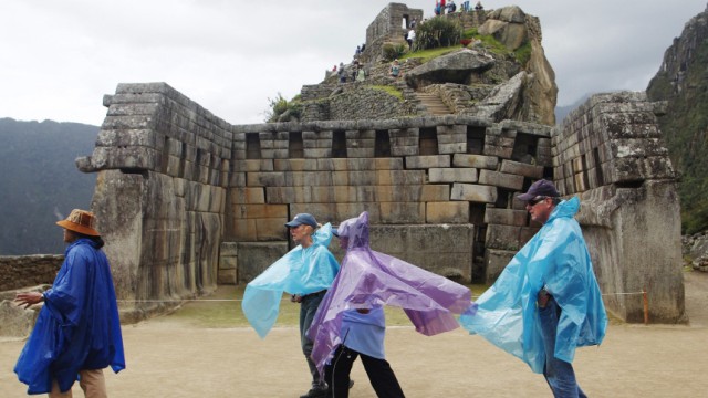 Tourists follow their guide at the Inca citadel of Machu Picchu in Cuzco