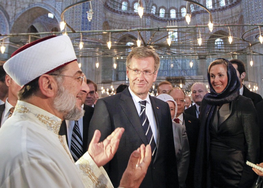 Germany's President Wulff  and his wife Bettina listen to Imam Hatipoglu during their visit to the Ottoman-era Sultanahmet Mosque in Istanbul