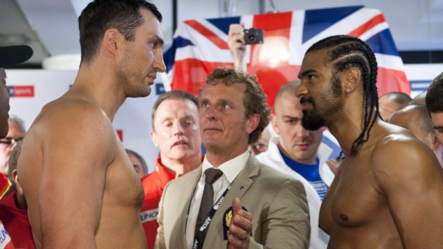 Official intermits as heavyweight boxers, IBF and WBO titleholder Klitschko of Ukraine and WBA champion Haye of Britain stand face to face after their weigh-in in Hamburg