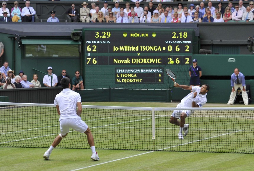 Jo-Wilfried Tsonga of France hits a return to Novak Djokovic of Serbia during their semi-final match at the Wimbledon tennis championships in London