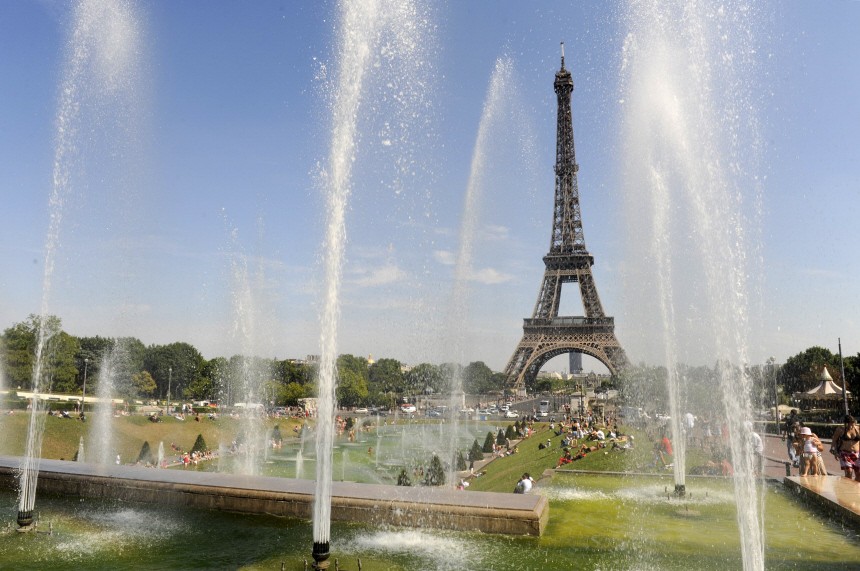 The Trocadero fountains shoot water into the air across from the Eiffel Tower on a hot summer day in Paris