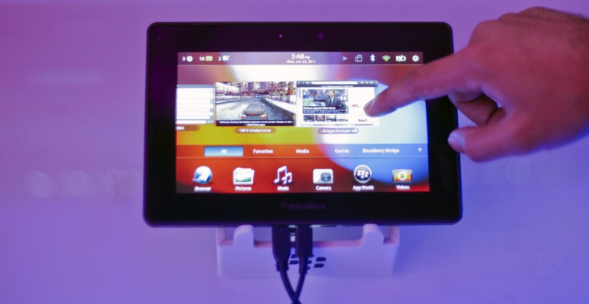 A conference attendee examines the BlackBerry PlayBook during its launch in Mumbai