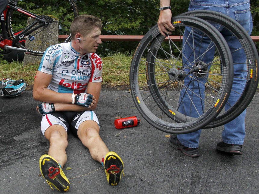 Omega Pharma Lotto rider Willems of Belgium holds his arm after a crash during the ninth stage of the Tour de France 2011
