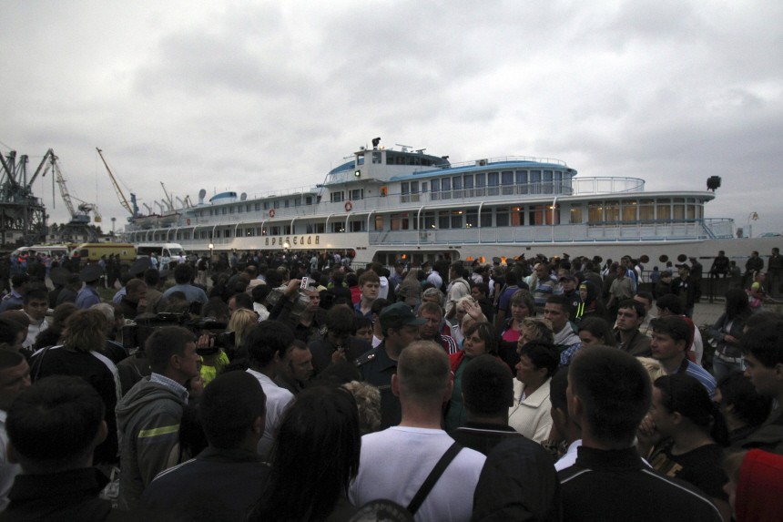 A crowd is seen in front of the Araballa motor ship, which transported survivors from a tourist boat that sank, after its arrival at the port of Kazan