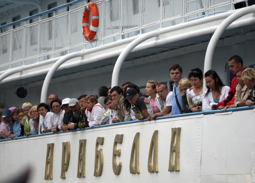 Passengers onboard the Arabella motor ship look out from the deck, after the ship rescued survivors from the Bulgaria tourist boat, at the port of Kazan