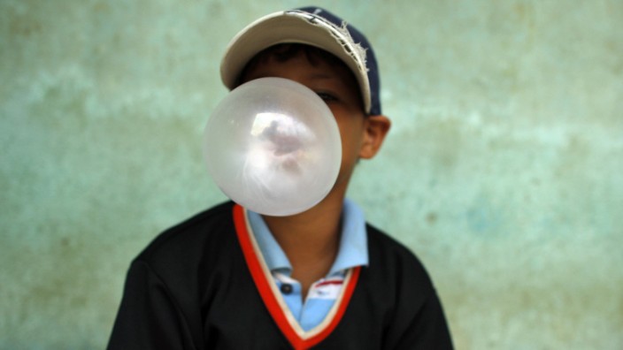 A child blows a bubble gum as he attends a donation of baseball equipments organized by Homerun hopefuls in Santo Domingo