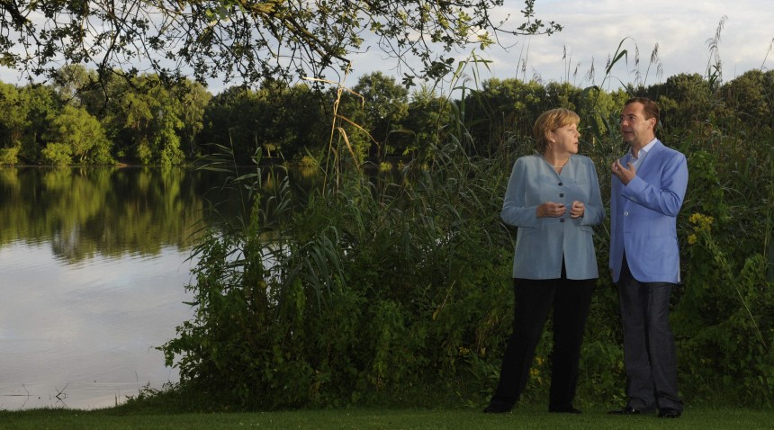 Russian President Medvedev and German Chancellor Merkel walk through a garden before their meeting during the German-Russian consultations in Hanover