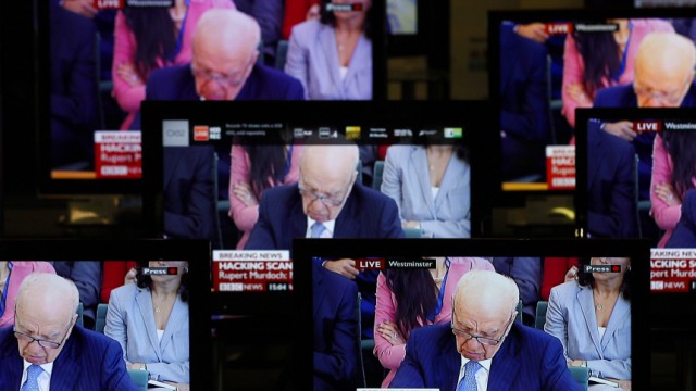 News Corp Chairman and Chief Executive Rupert Murdoch is seen on television screens in an electrical store as he is questioned by a parliamentary committee on phone hacking, in Edinburgh