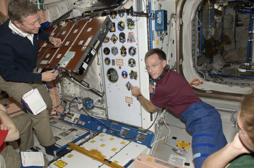 NASA handout photo shows space shuttle Atlantis Commander Ferguson adding his mission's decal as the final piece of the collection of shuttle crew insignias